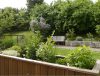 Ein Hochbeet und eine Bank im Garten der Tagespflege Kreuzkirche